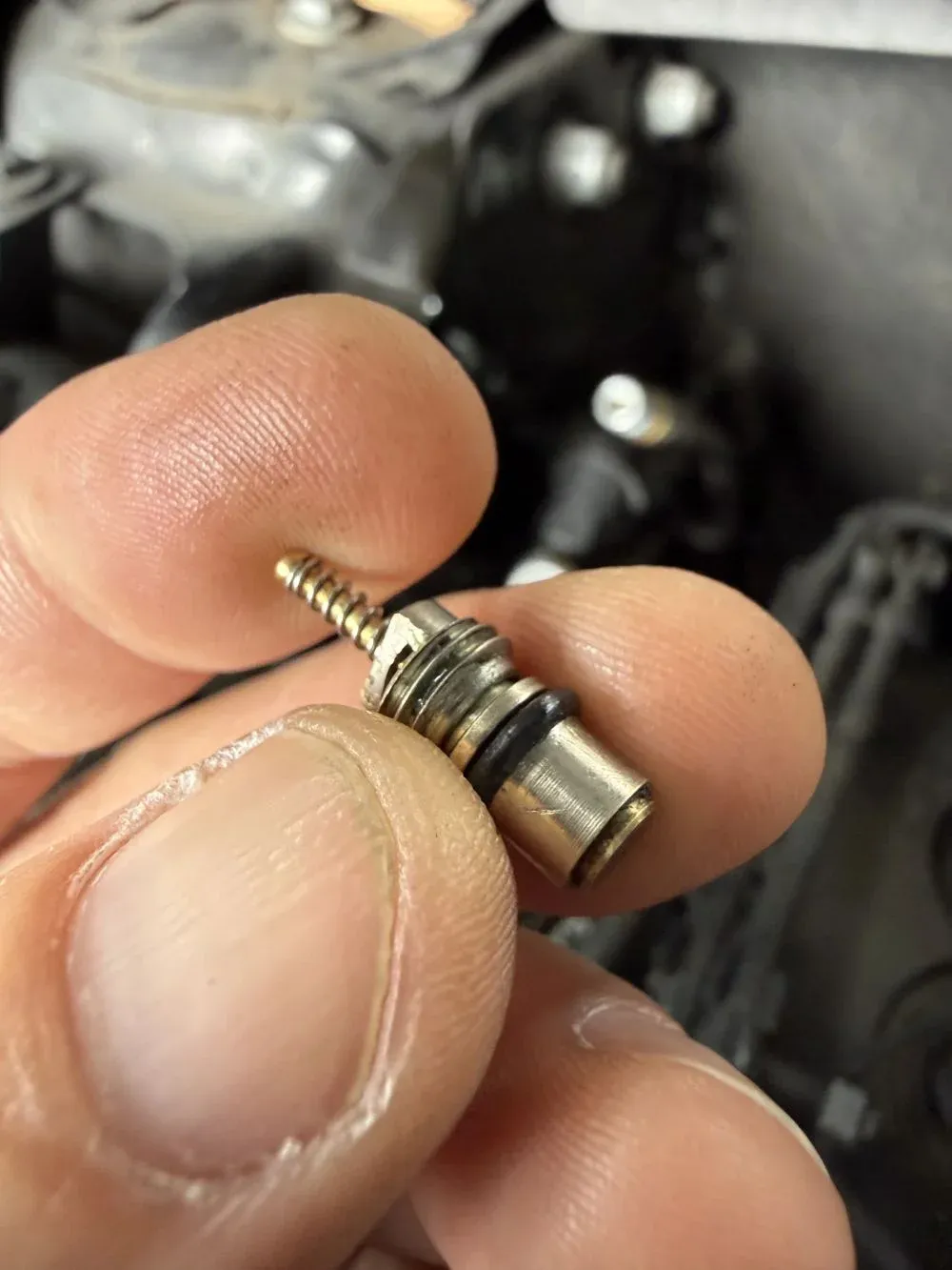 AC service-port valve stem closeup showing the worn rubber seal that was leaking refrigerant at Beacon Auto Care San Mateo