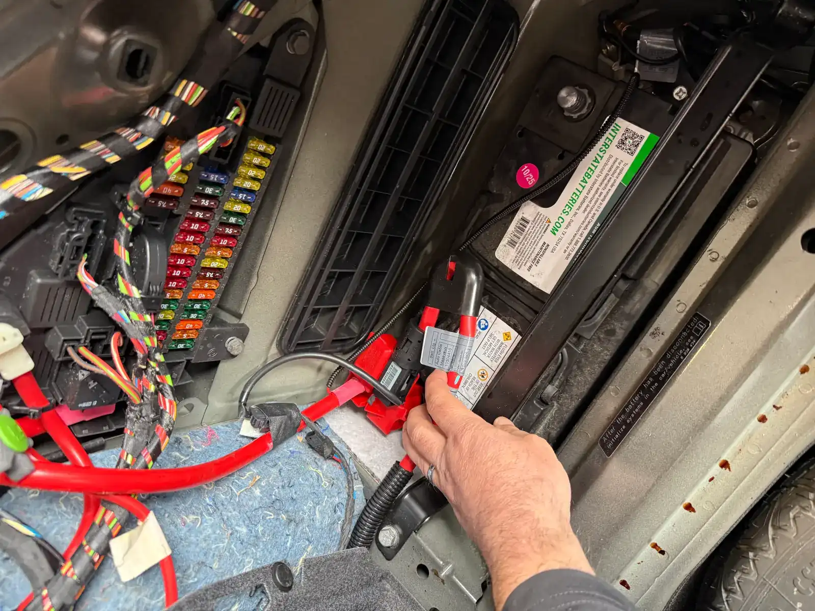 Mechanic attaching the positive battery cable terminal during a battery replacement at Beacon Auto Care San Mateo