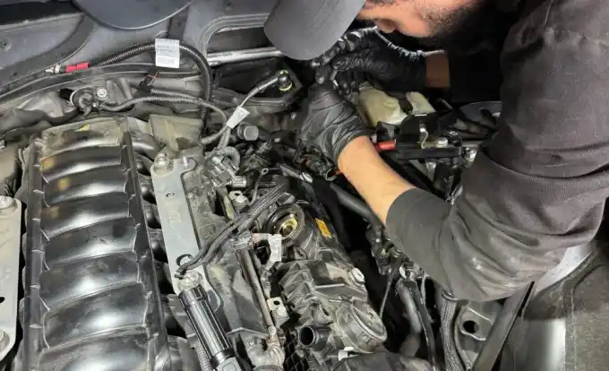 Favio working on a 2006 BMW 550i N62 V8 valve cover replacement at Beacon Auto Care San Mateo