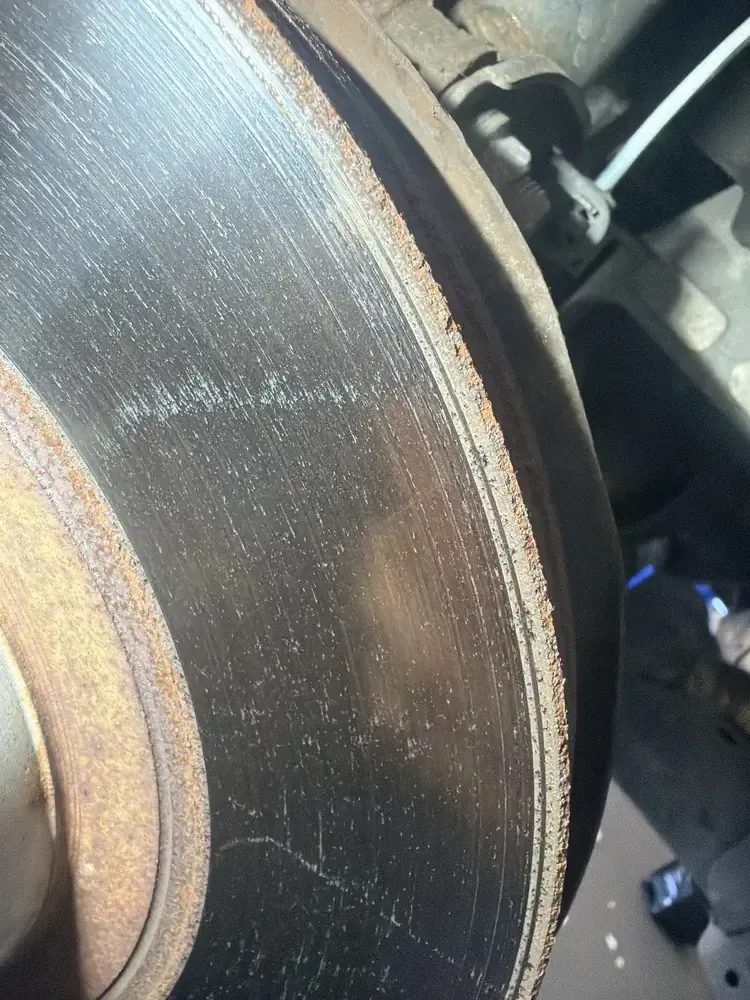 Brake rotor grooves and wear pattern visible during inspection at Beacon Auto Care San Mateo