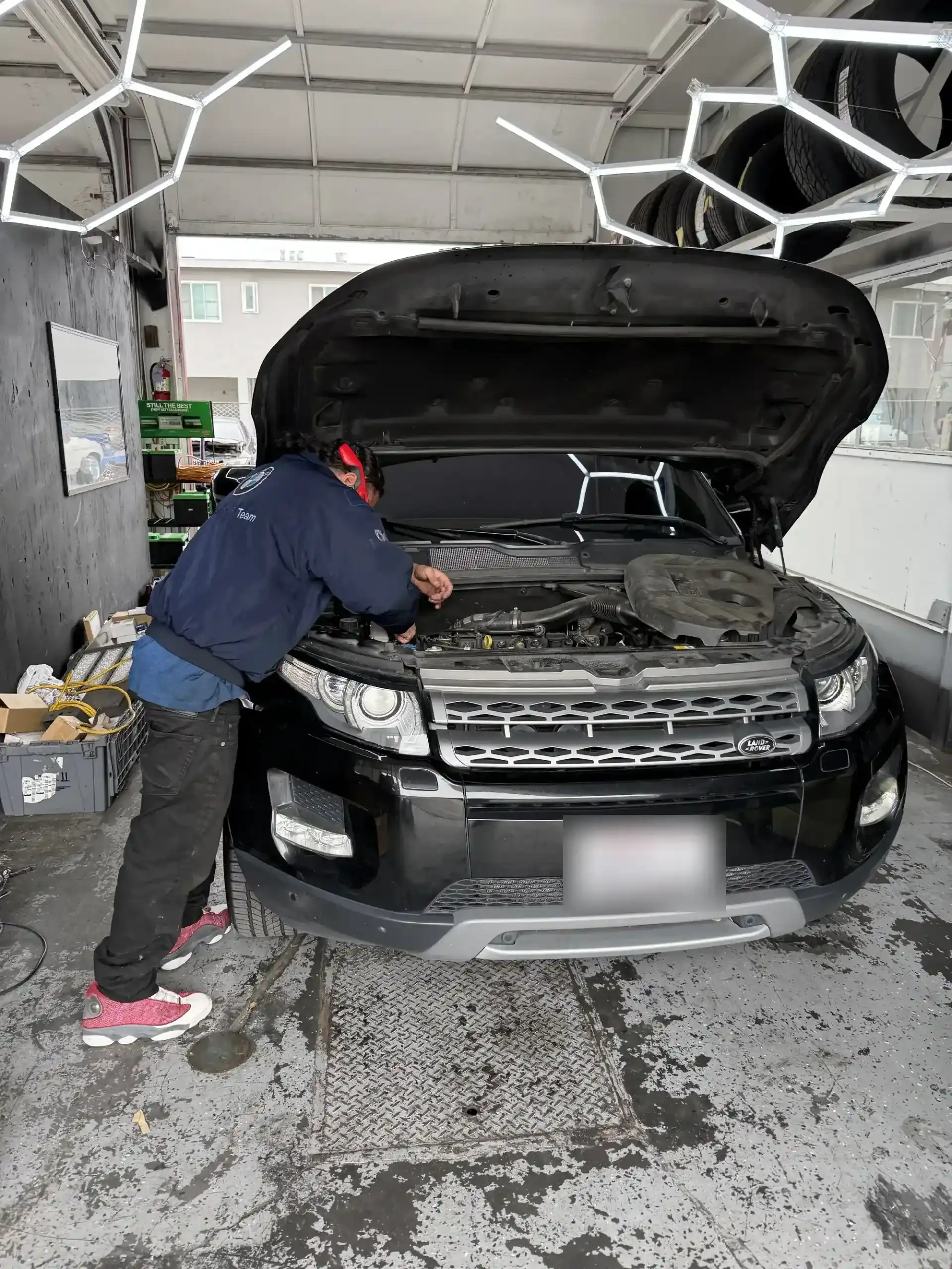 Range Rover Evoque with the hood up in a service bay at Beacon Auto Care San Mateo