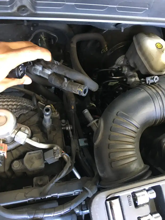Technician holding a disconnected evaporation hose found completely off during a 2013 Hyundai Sonata inspection in San Mateo