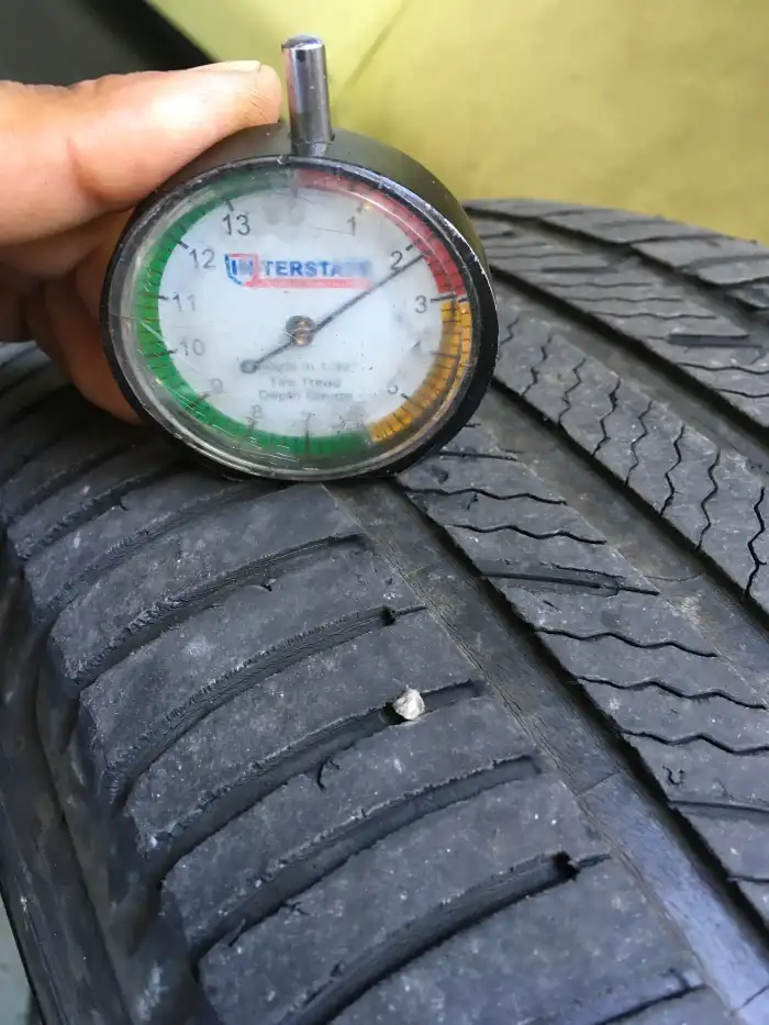 Tire tread depth gauge reading 2/32 on the worn front-left tire of a 2013 Hyundai Sonata in San Mateo