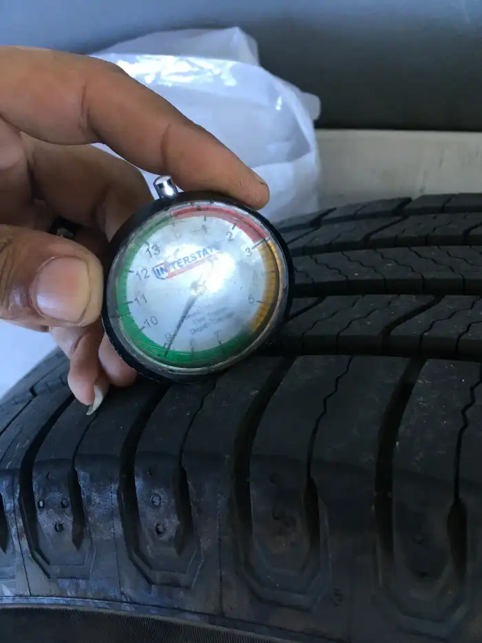 Tread depth gauge showing a healthy reading on the rear tire of a 2013 Hyundai Sonata during a San Mateo inspection