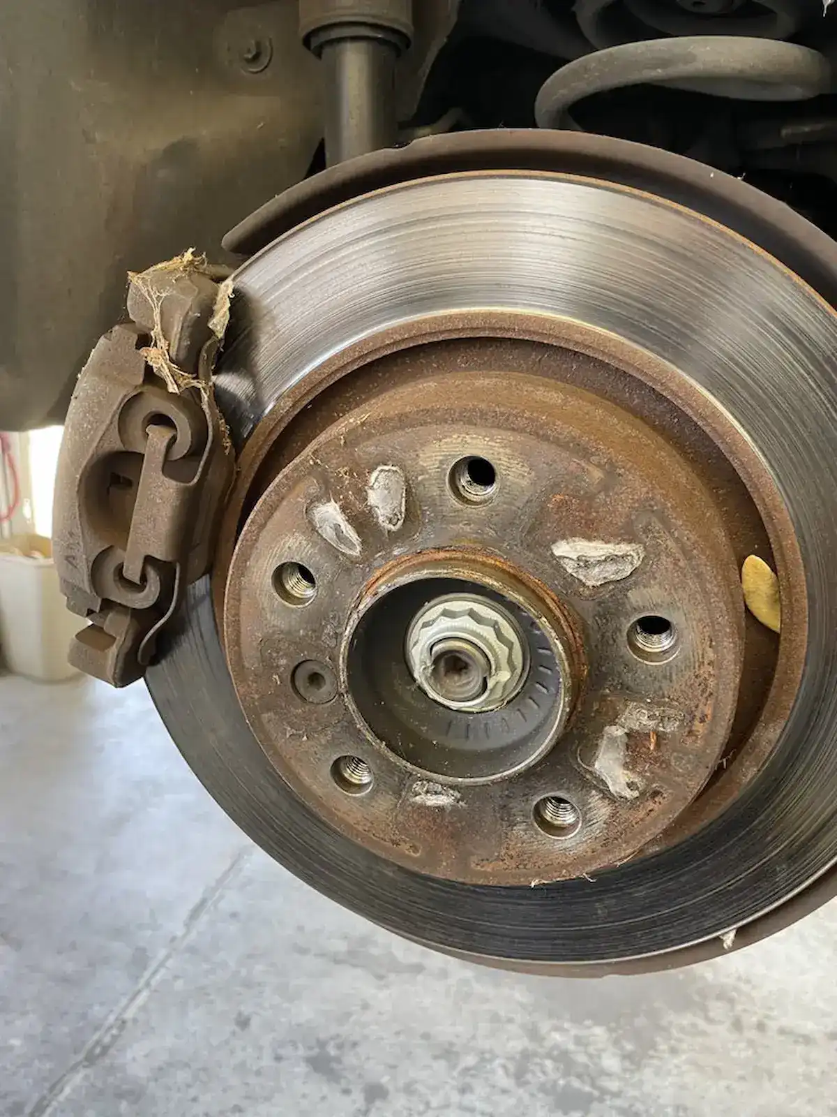 Worn brake rotor and caliper close-up at Beacon Auto Care San Mateo