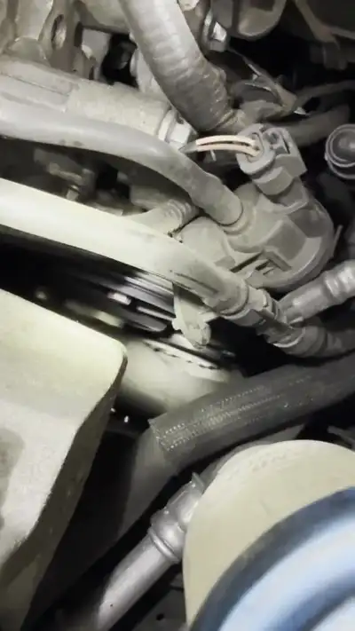 Close-up of an automotive A/C Schrader service valve and compressor — shop clip thumbnail